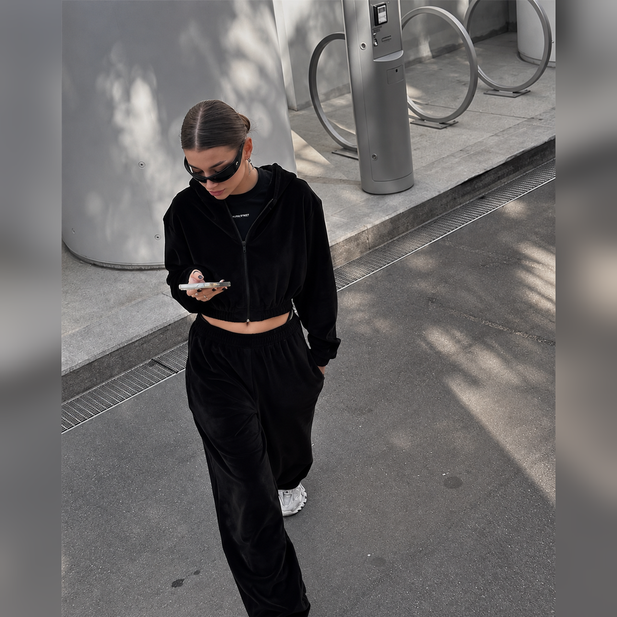 Black cropped hoodie and baggy pants tracksuit set styled as a relaxed streetwear outfit
