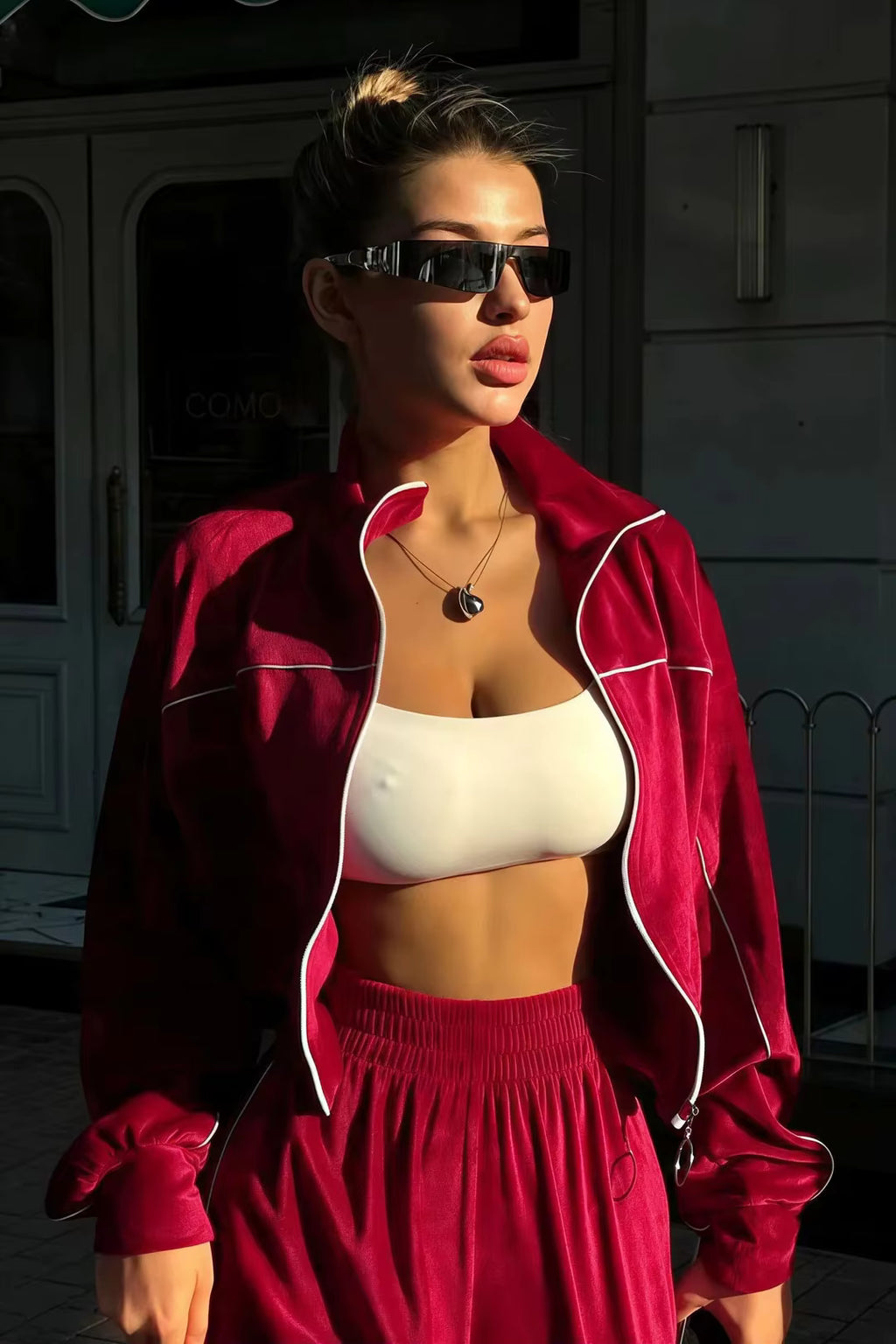 Burgundy red contrast-piping cropped track jacket styled open over a white crop top