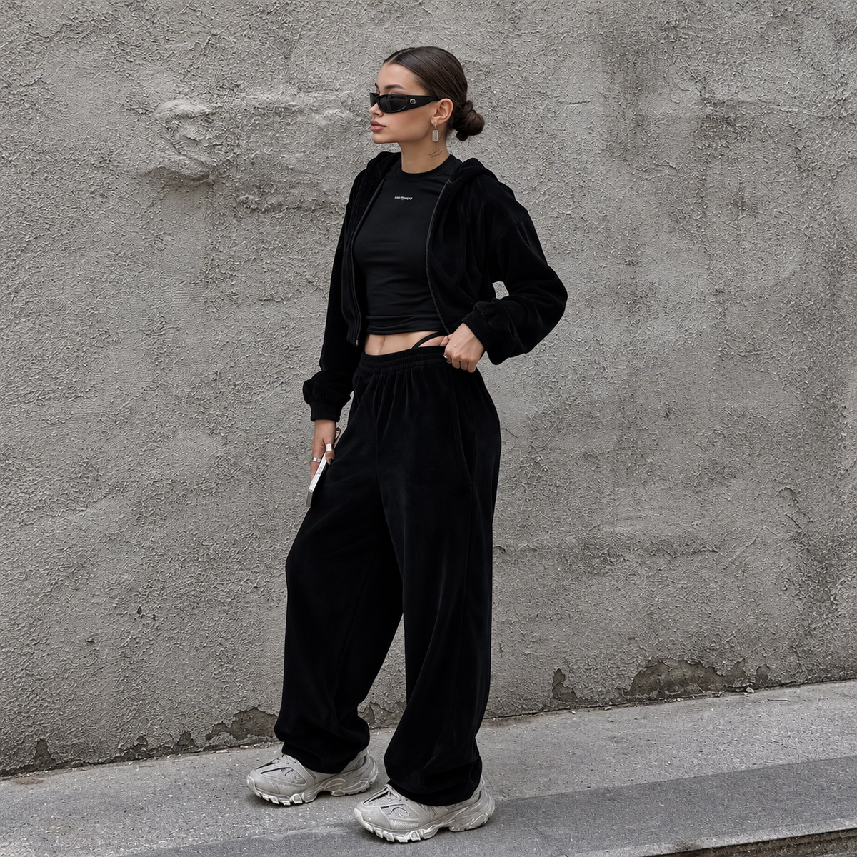 Black cropped hoodie tracksuit with relaxed polyester pants and chunky sneakers