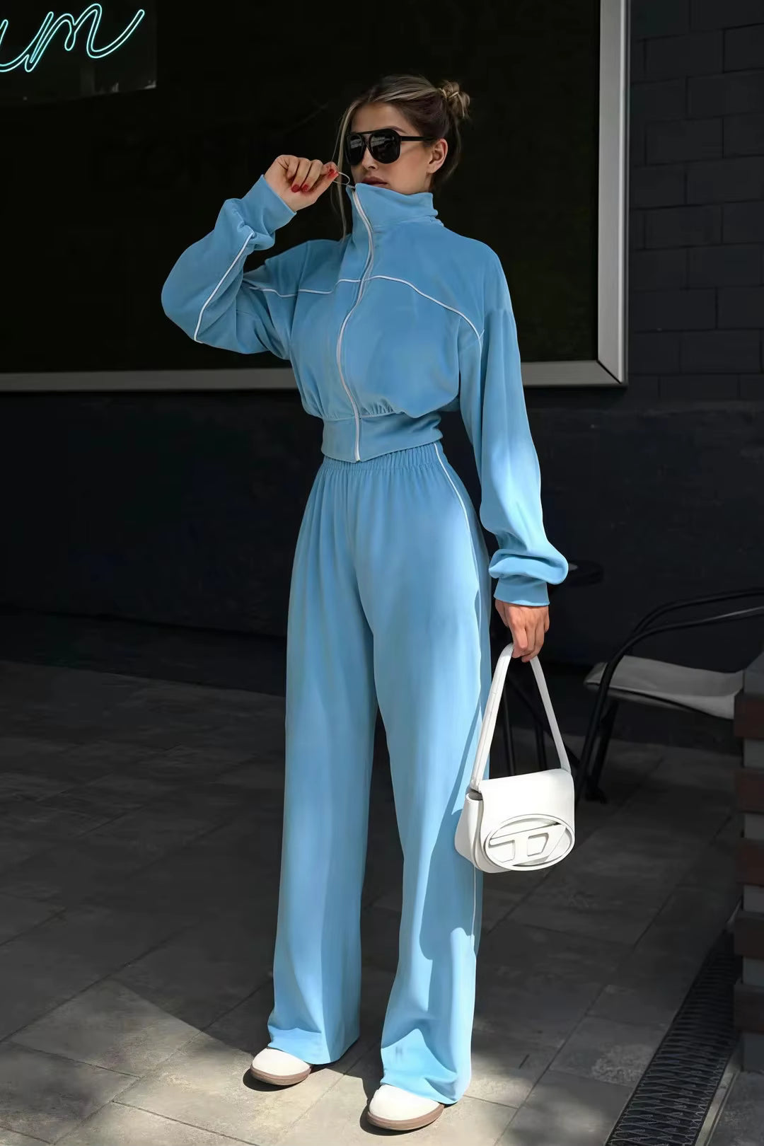Sky blue high-collar track jacket and wide-leg pants set with white contrast piping and shoulder bag