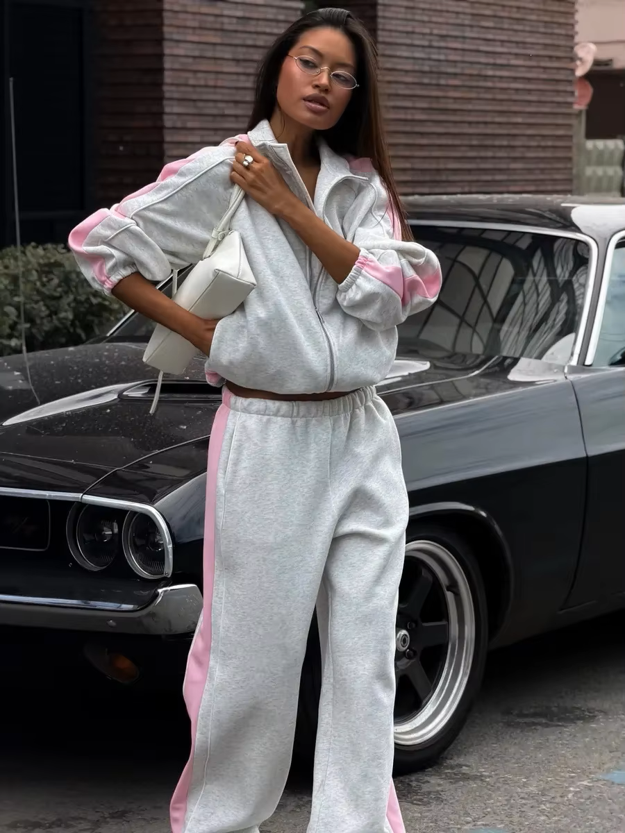 Heather gray tracksuit with pink side stripes, zip track jacket and wide-leg pants styled beside a classic car