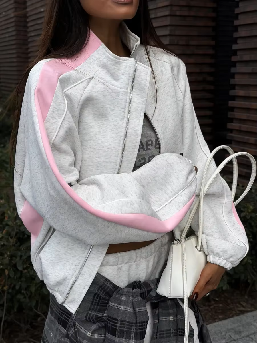 Gray and pink contrast stripe track jacket close-up with high collar and relaxed sleeves