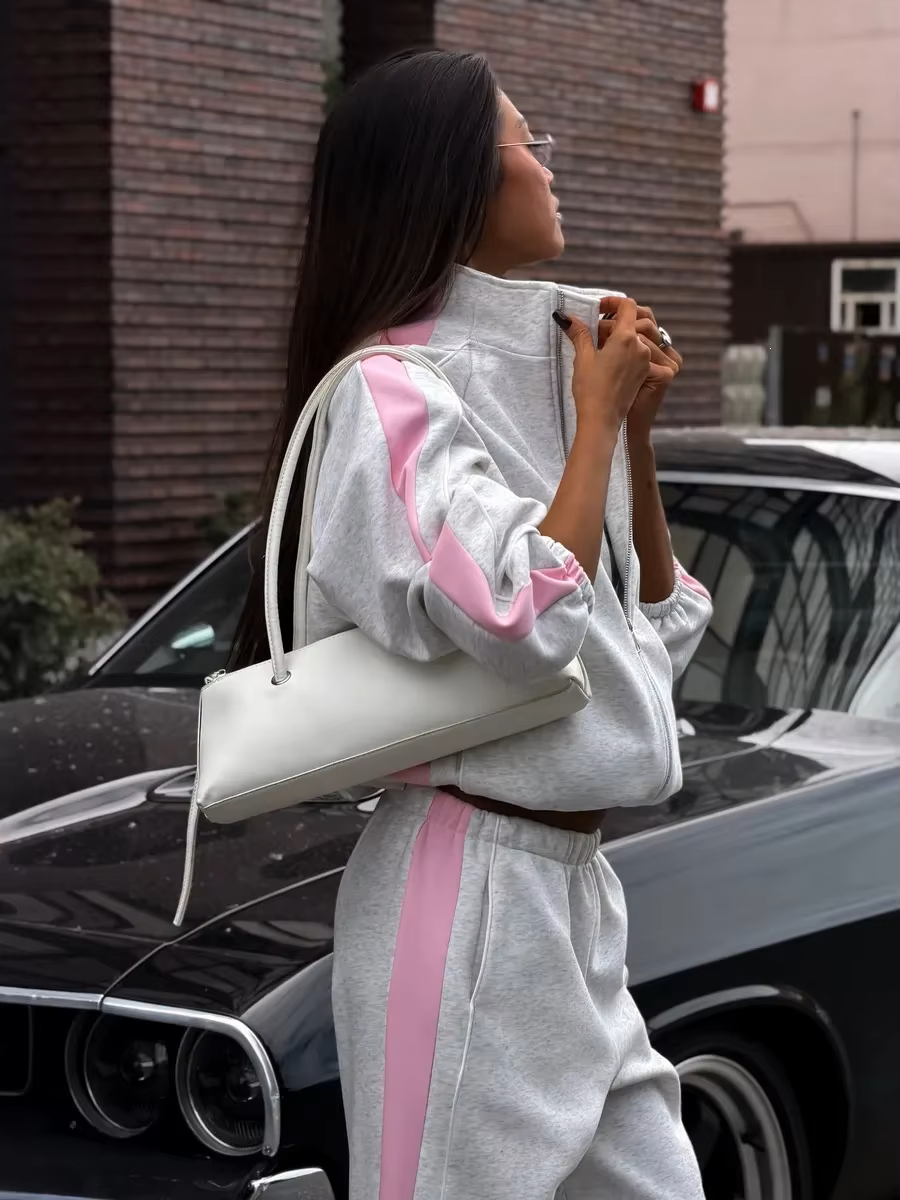 Gray and pink contrast stripe track jacket close-up with high collar and relaxed sleeves