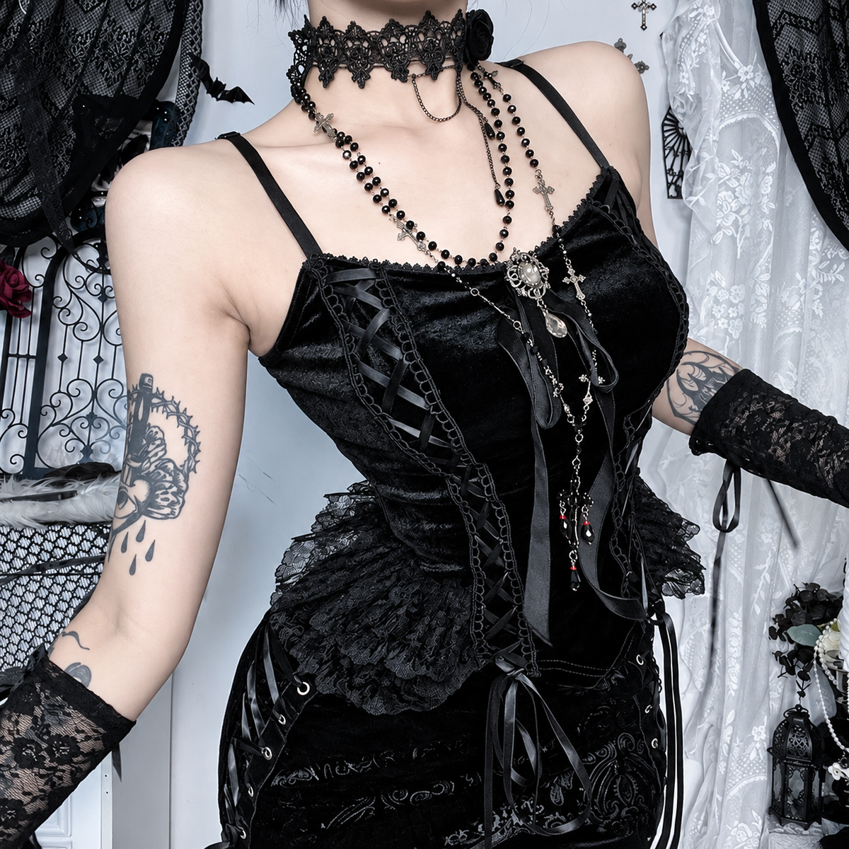 Black velvet corset top with side ribbon lacing, ruffle trim and ornate center detail