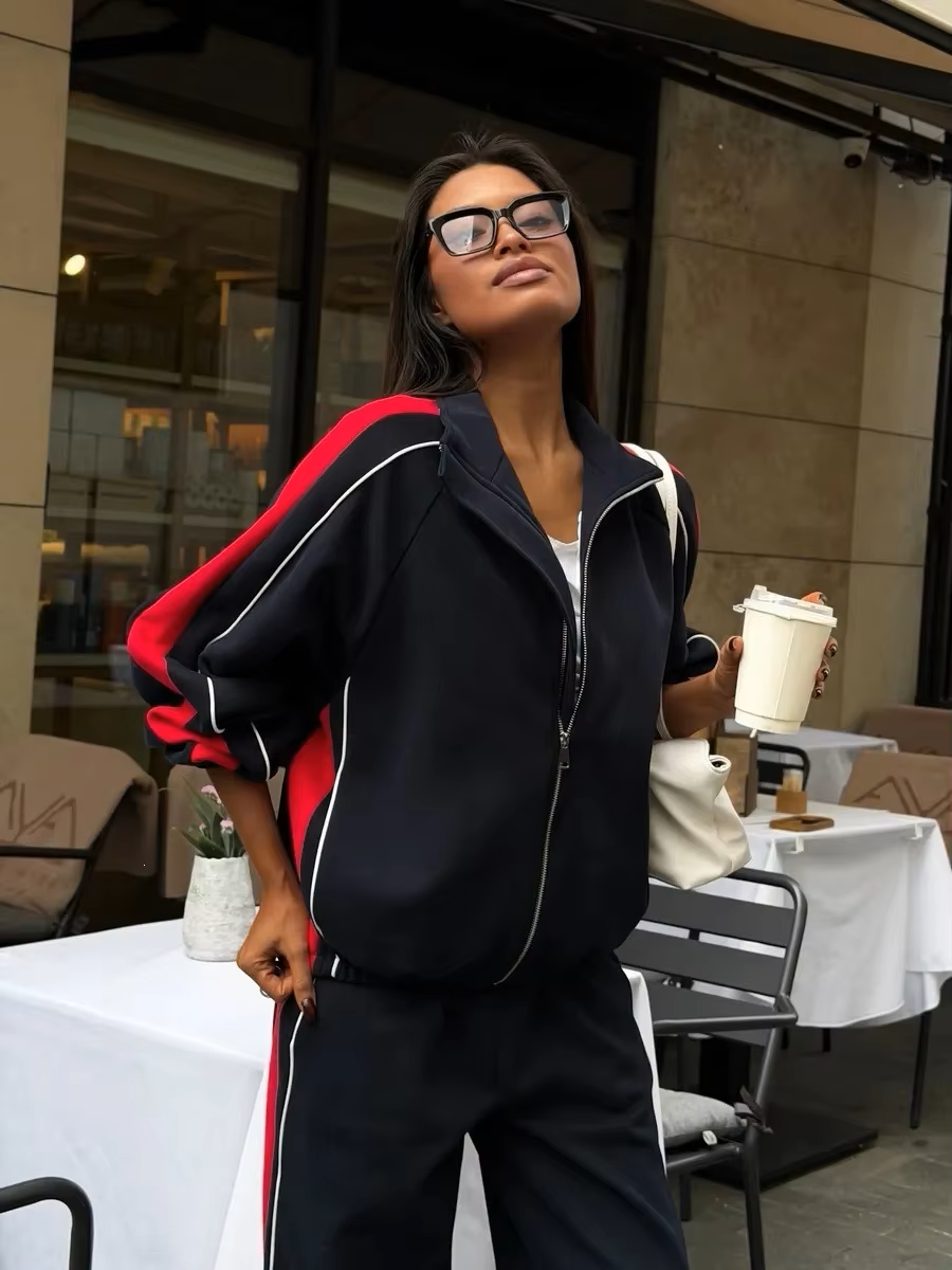 Navy and red striped tracksuit set with zip track jacket and relaxed wide-leg pants styled outdoors