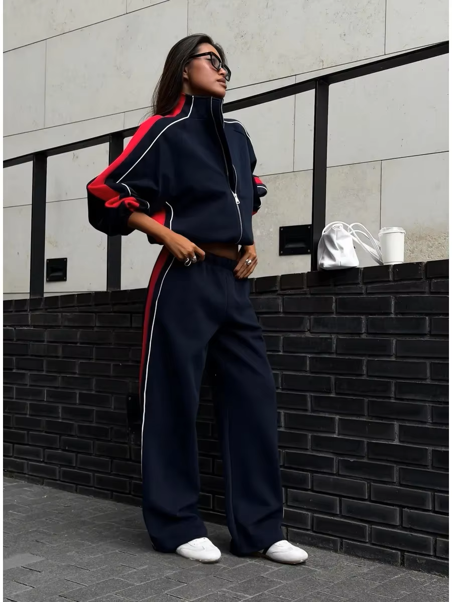 Navy and red striped tracksuit set with zip track jacket and relaxed wide-leg pants styled outdoors