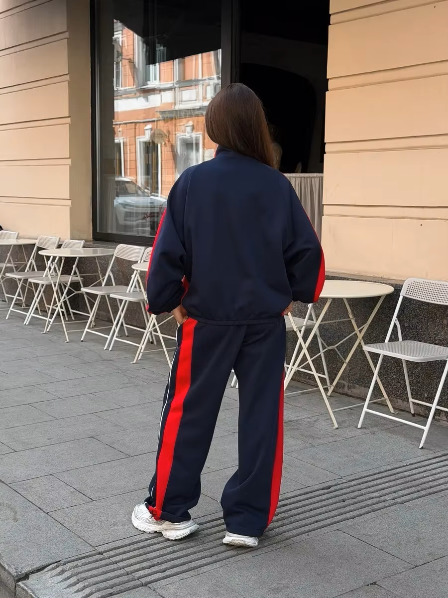Back View Navy and red striped tracksuit set with zip track jacket and relaxed wide-leg pants styled outdoors
