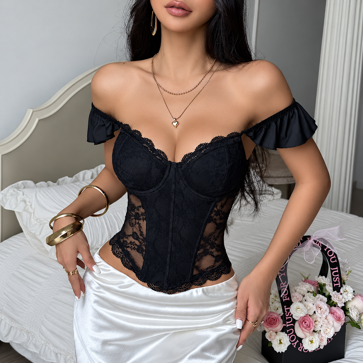 Black lace ruffle corset top styled off shoulder with a white satin skirt, front view