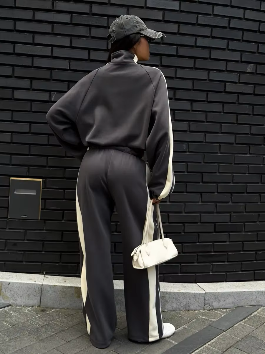 Back view of charcoal gray tracksuit with cream side panels and full-length wide-leg pants