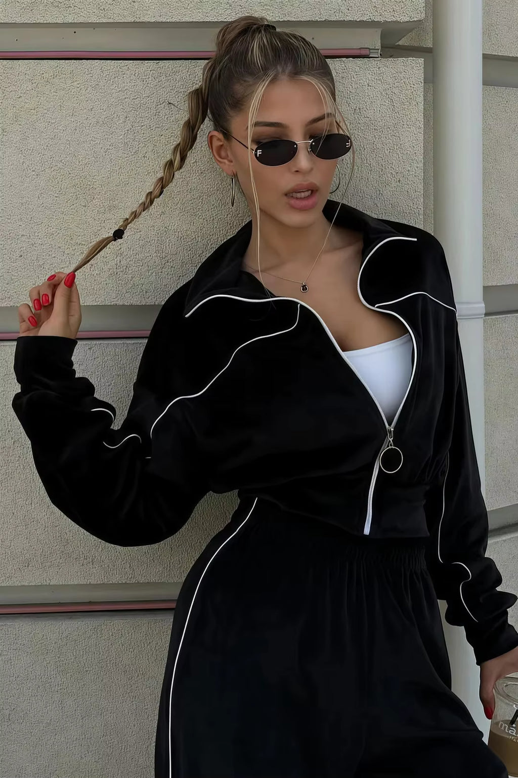 Black contrast-piping track jacket close-up with ring zipper, high collar and cropped fit