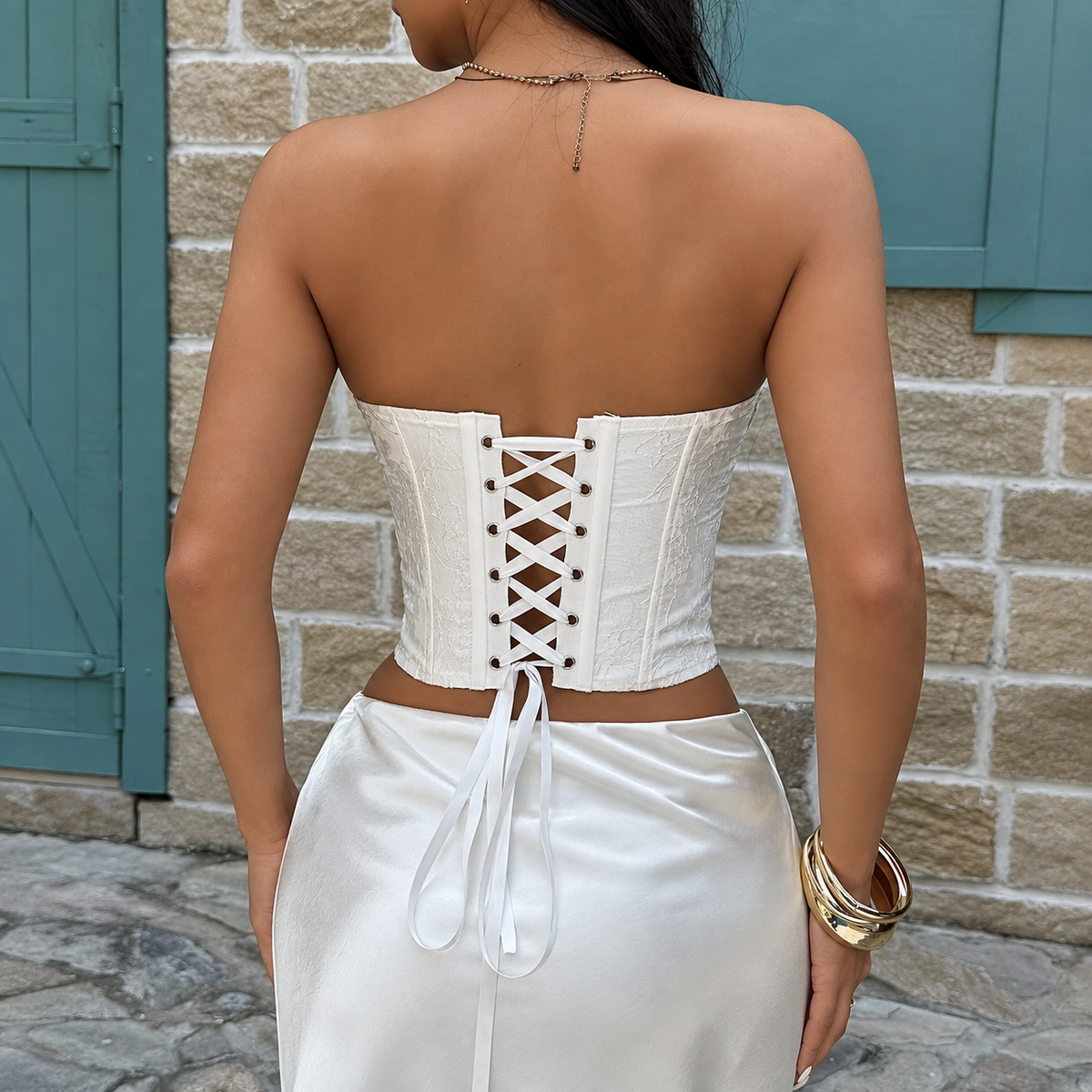 Back view of white floral corset top with ribbon lace-up closure and fitted longline silhouette