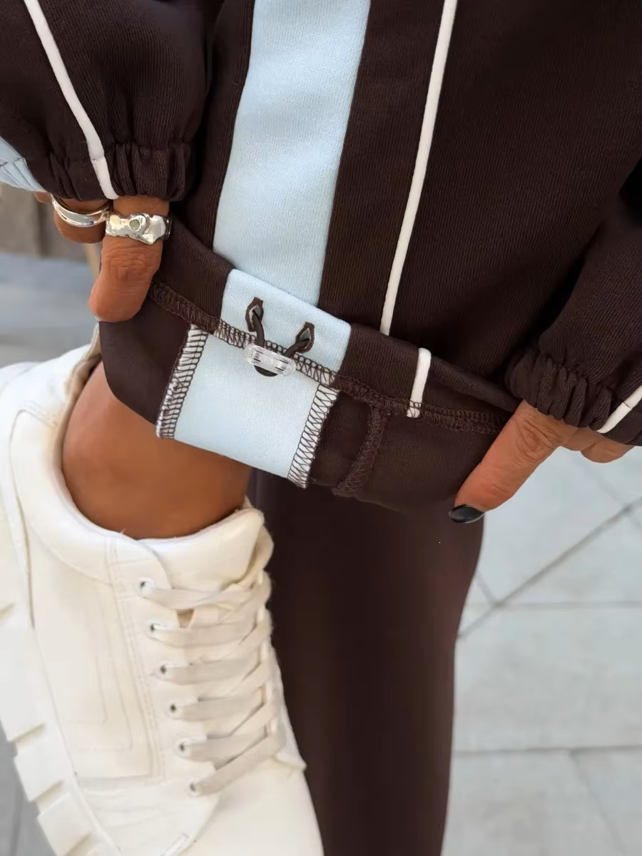 Chocolate brown contrast stripe tracksuit side view with relaxed zip jacket and wide-leg pants